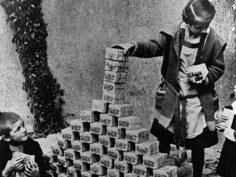 boy stacking worthless paper money